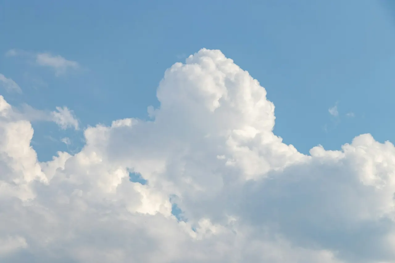Sunlit clouds against an open blue sky